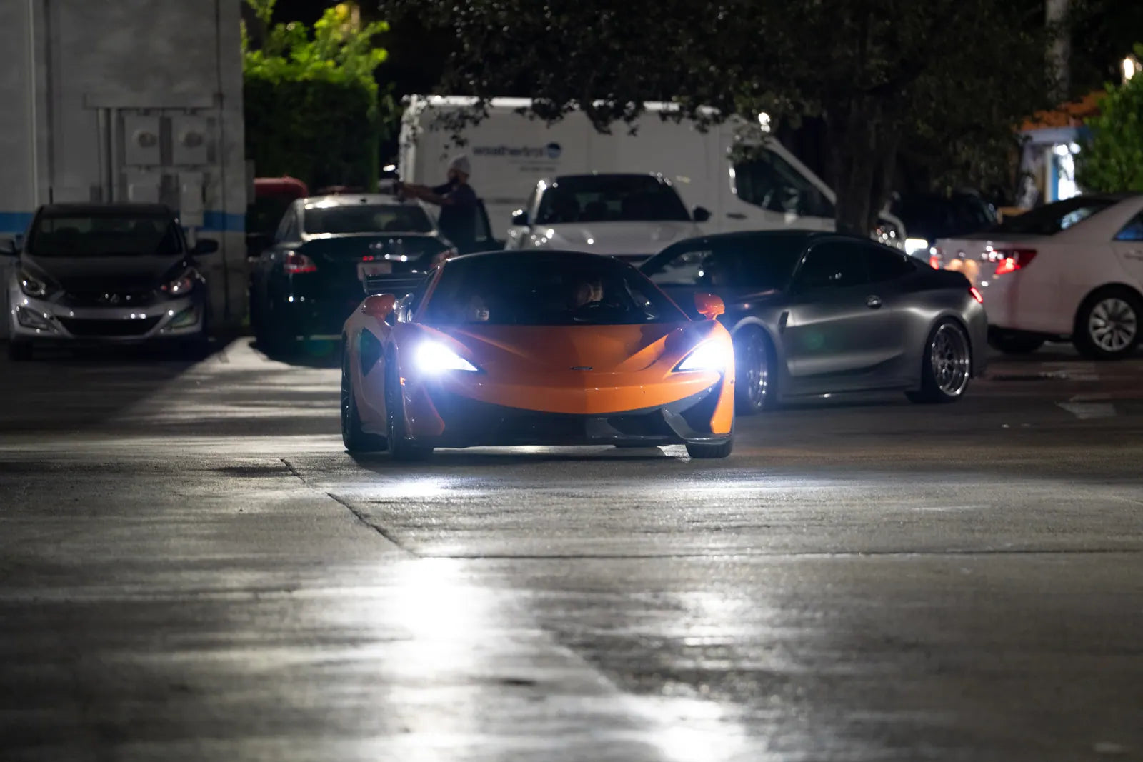 McLaren pulling into the lot with headlights on