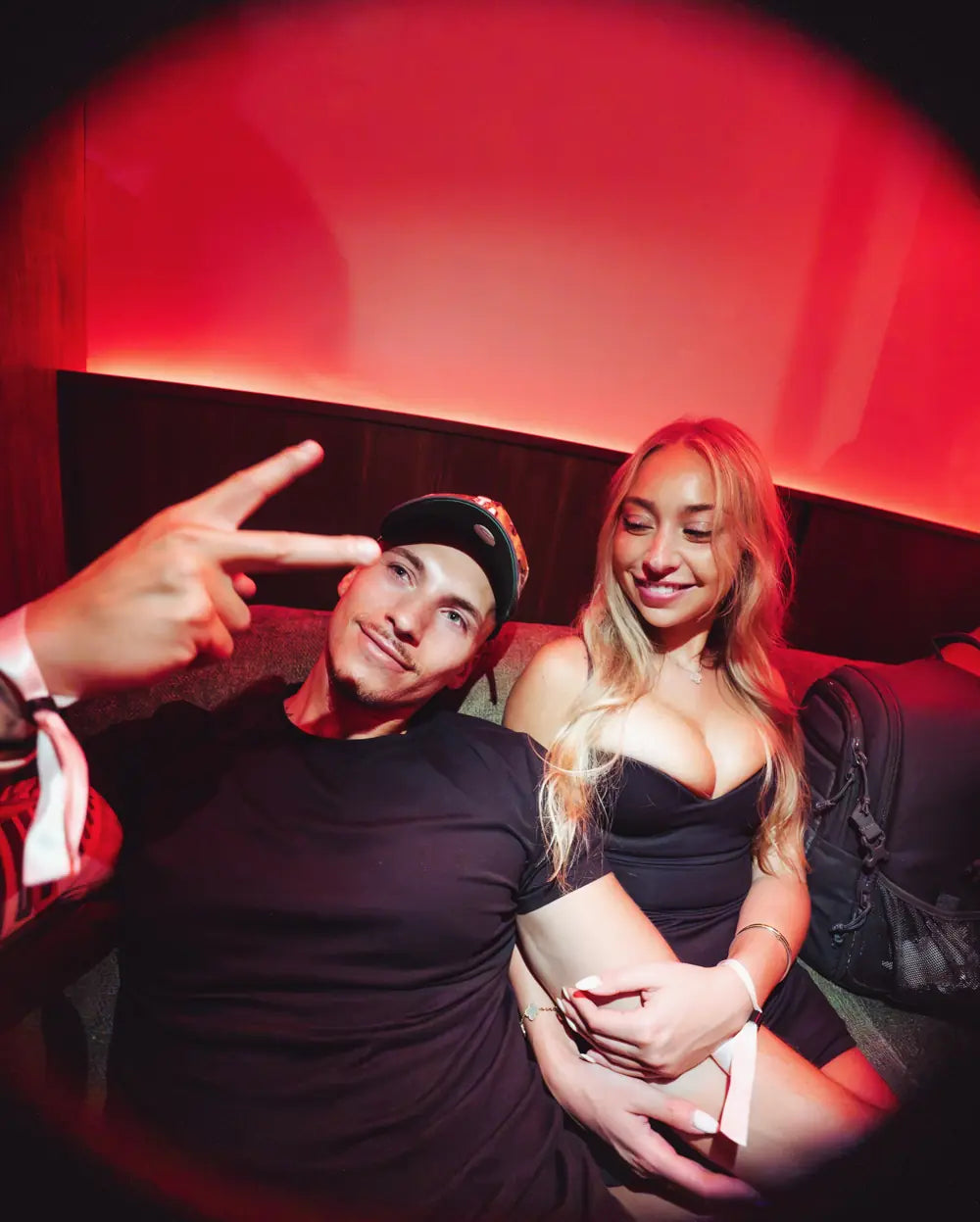 Two guests in the red-lit lounge at Cars and Cameras